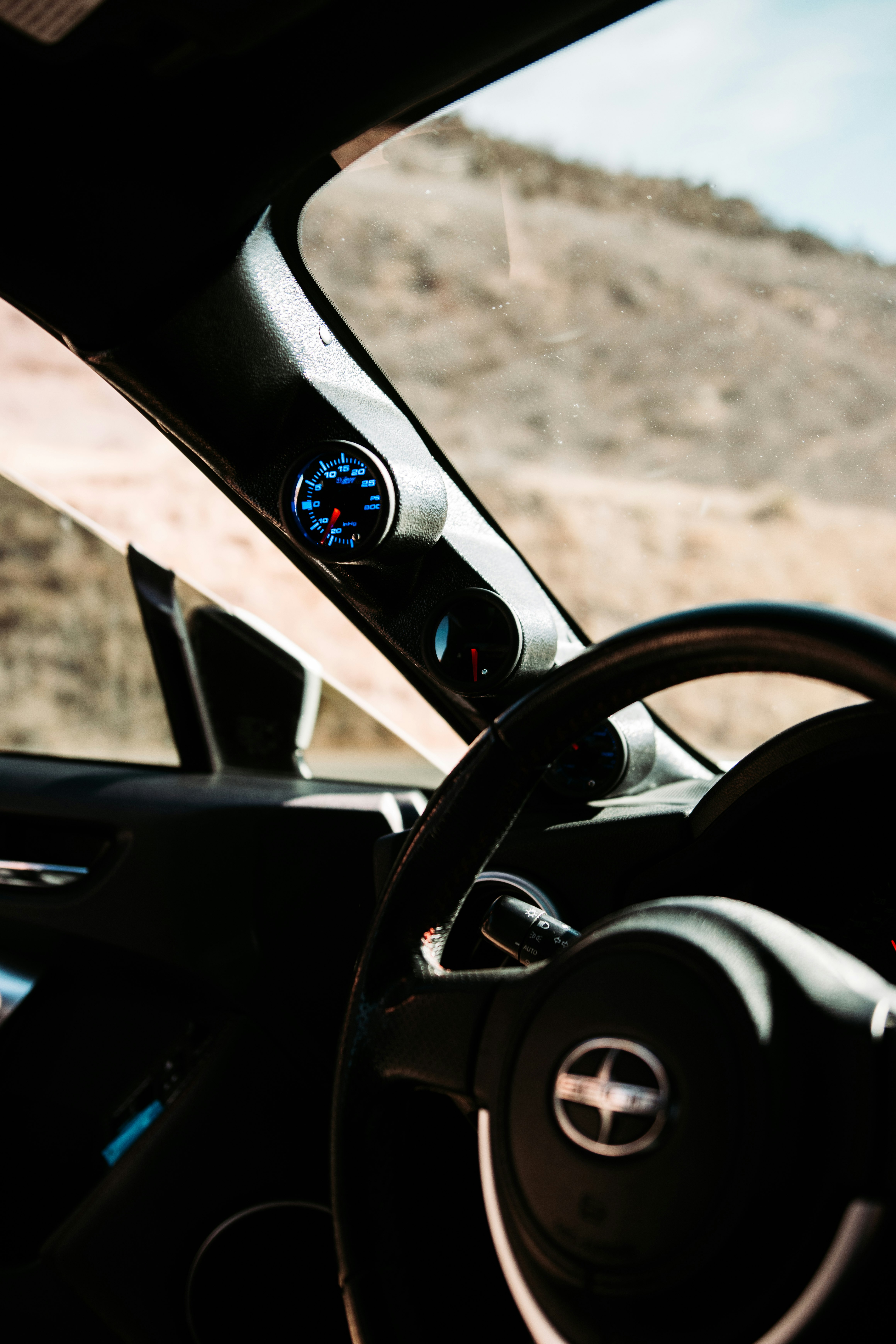 black car steering wheel during daytime